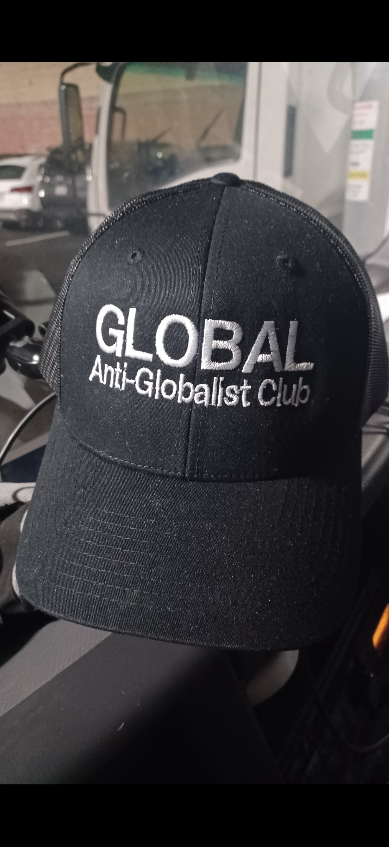 Global Anti-Globalist Club black trucker hat with white embroidered logo